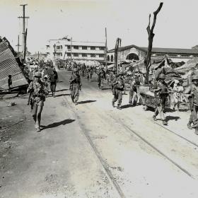 Troops walking through destroyed Manila, Philippines.